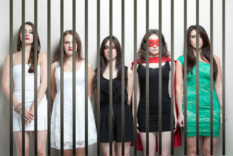 A group of women wearing costumes in a police line up, concept of common crimes committed on Halloween