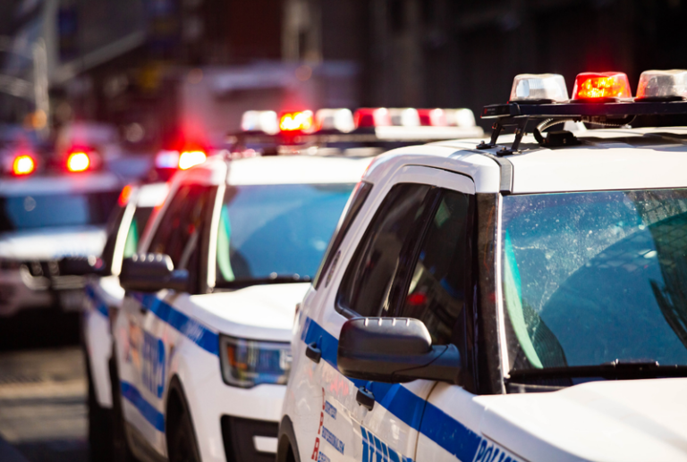 Image is of a row of police vehicles with their lights on, concept of probation violations and how to avoid them