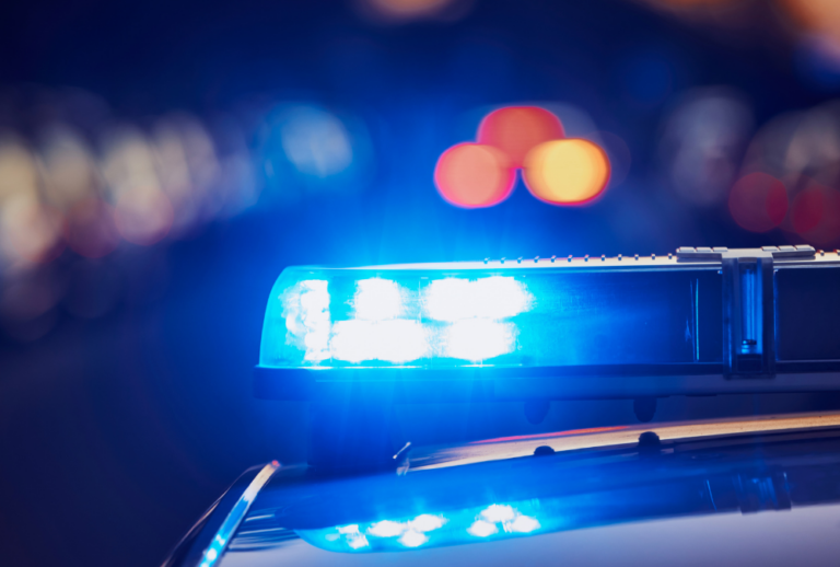 Image is of a closeup of a police car lights at night, concept of knowing your rights and police conduct and use of force in Florida