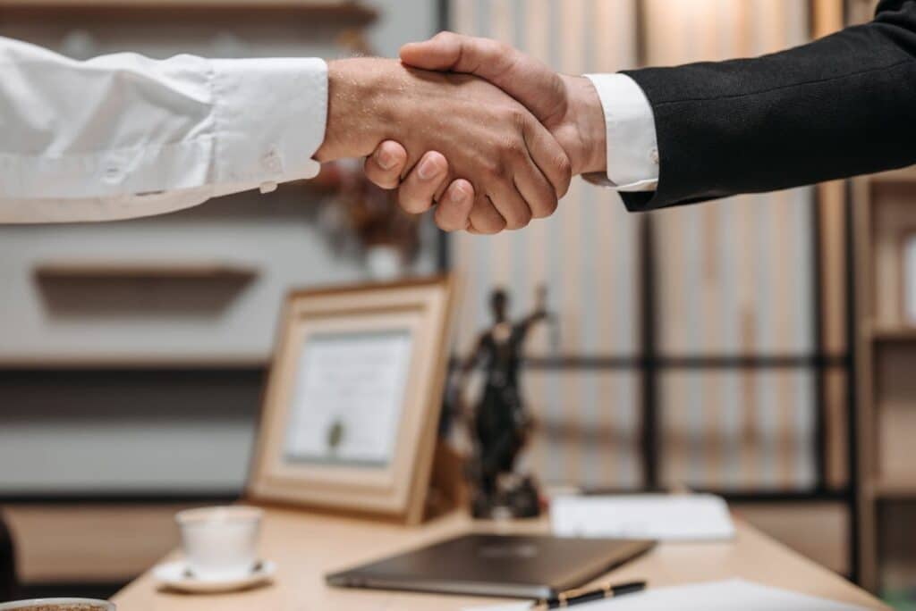 Close-up of handshake between attorney and client in office, representing trust after a DUI arrest.