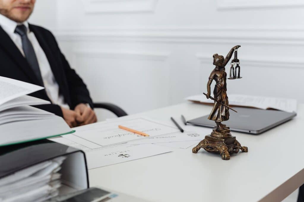 Lawyer’s desk with Lady Justice statue and legal documents, symbolizing first steps after a DUI arrest.
