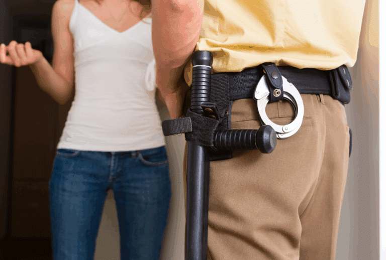 Image is of a close up of a police officer standing at the front door of a home and speaking to a woman who lives there, concept of your rights during a "knock and talk" in Ponte Vedra Beach