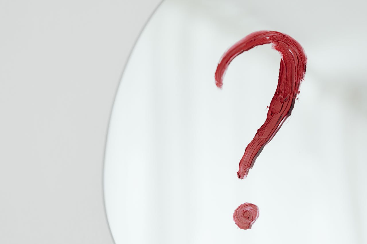 Red question mark on a mirror representing confusion about insurance rate changes.