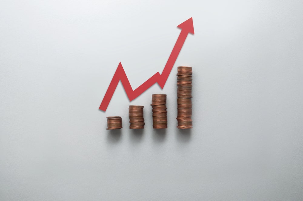 Stacks of coins with an upward red arrow showing how a DUI affects your insurance rates.