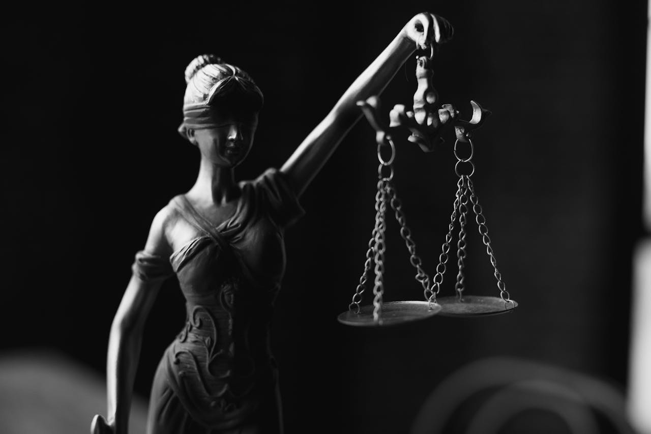 Image shows a statue of Lady Justice holding scales symbol of fairness and legal judgment