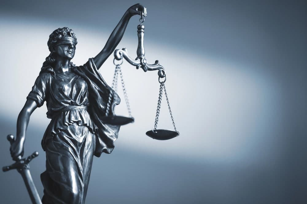 Image is of a Lady Justice statue holding balanced scales, symbolizing how courts interpret and enforce rules about drug paraphernalia under Florida law.