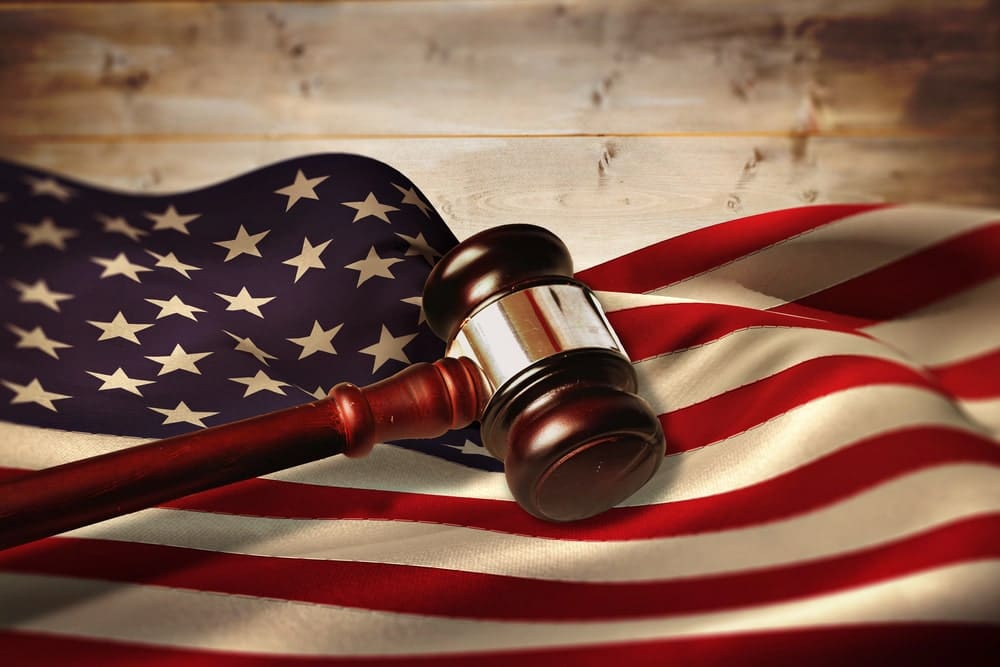 Image is of a judge’s gavel resting on an American flag, illustrating legal authority and firearm restrictions following a DV conviction in Florida
