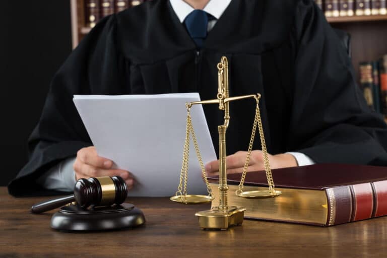 Image is of a judge reviewing legal documents at a desk with a gavel and justice scales, symbolizing the judicial review process involved in a DUI conviction appeal.