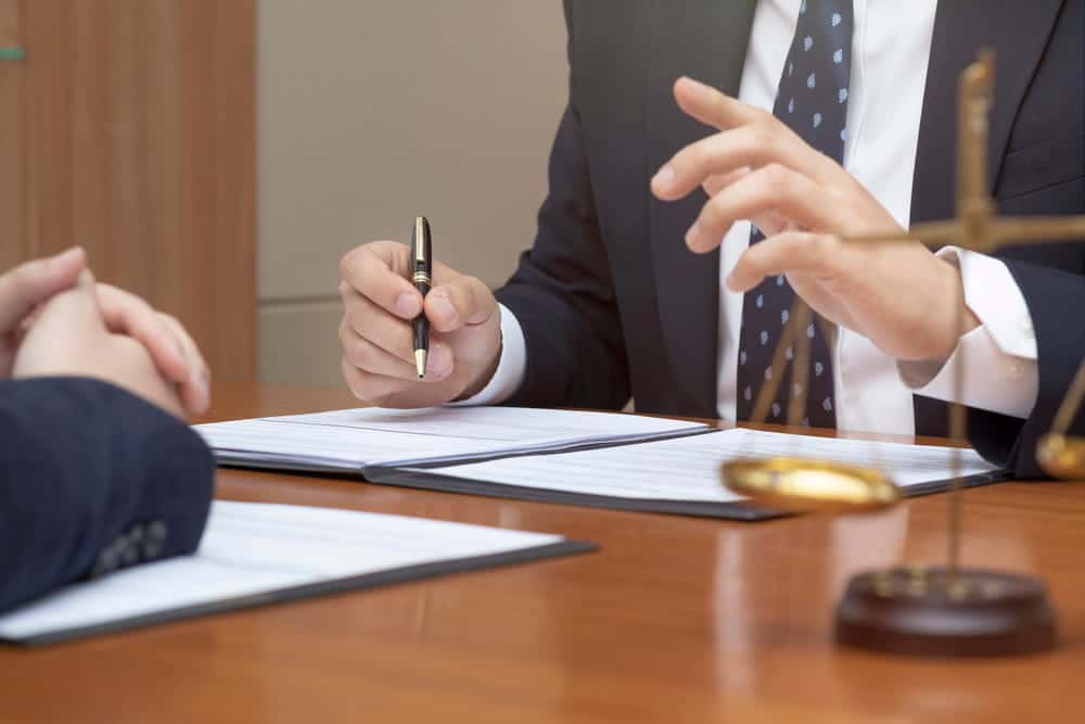 Image is of a lawyer discussing legal documents with a client, concept of DUI charge review and case evaluation