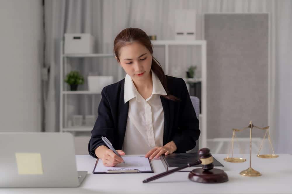 Image is of an attorney reviewing paperwork at a desk, representing legal preparation for defending against false DV allegations.