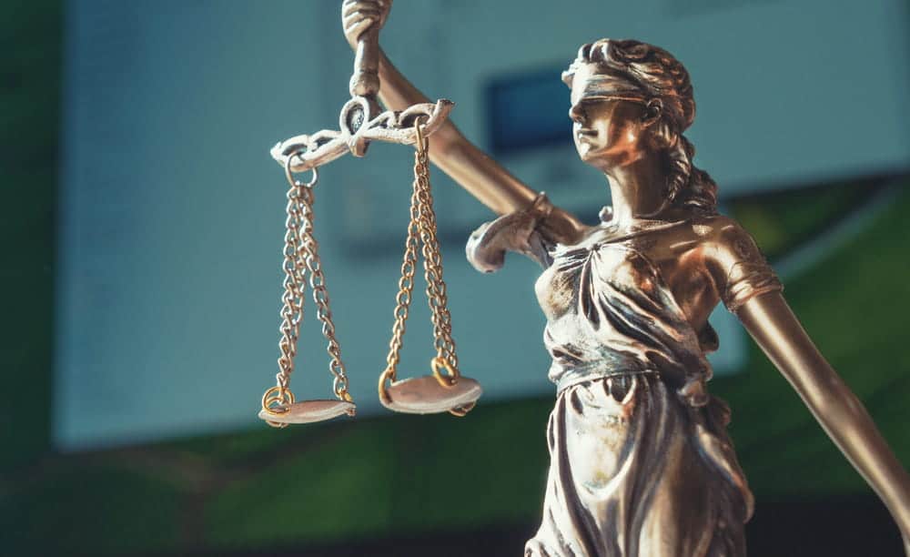 Image is of a Lady Justice statue holding scales, concept of drug possession in Ponte Vedra legal evaluation and court decision process