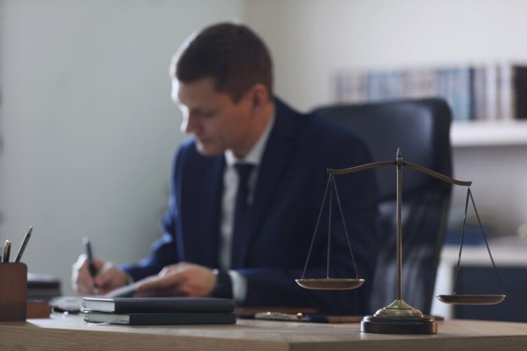 Image is of a lawyer reviewing documents at a desk with scales of justice, concept of drug possession in Ponte Vedra case analysis and legal preparation