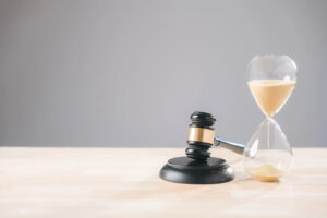 Image is of a gavel placed beside an hourglass, concept of time and legal process in a DUI case