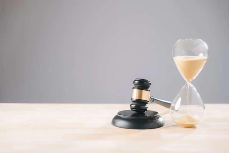 Image is of a gavel placed beside an hourglass, concept of time and legal process in a DUI case