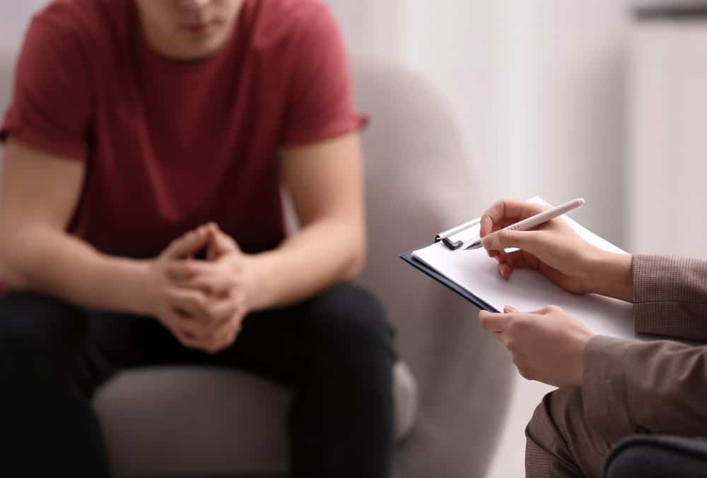 Image is of a person speaking with a legal professional during a consultation, concept of discussing options for expunging a drug charge in Florida.