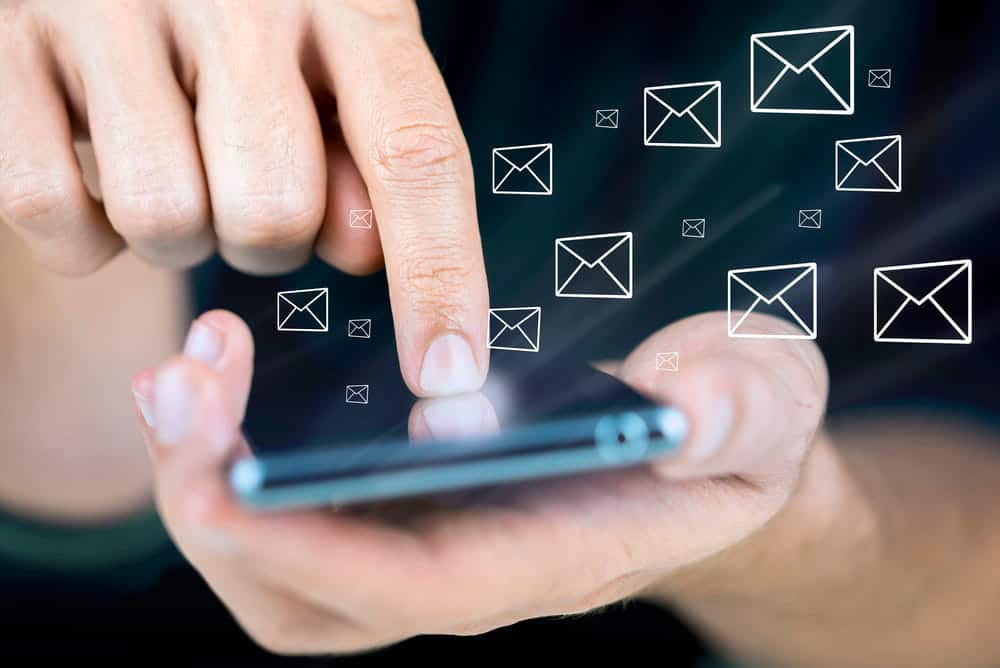 Image is of a person using a smartphone with floating message icons on the screen, concept of mobile phone evidence and communication records in DV cases.
