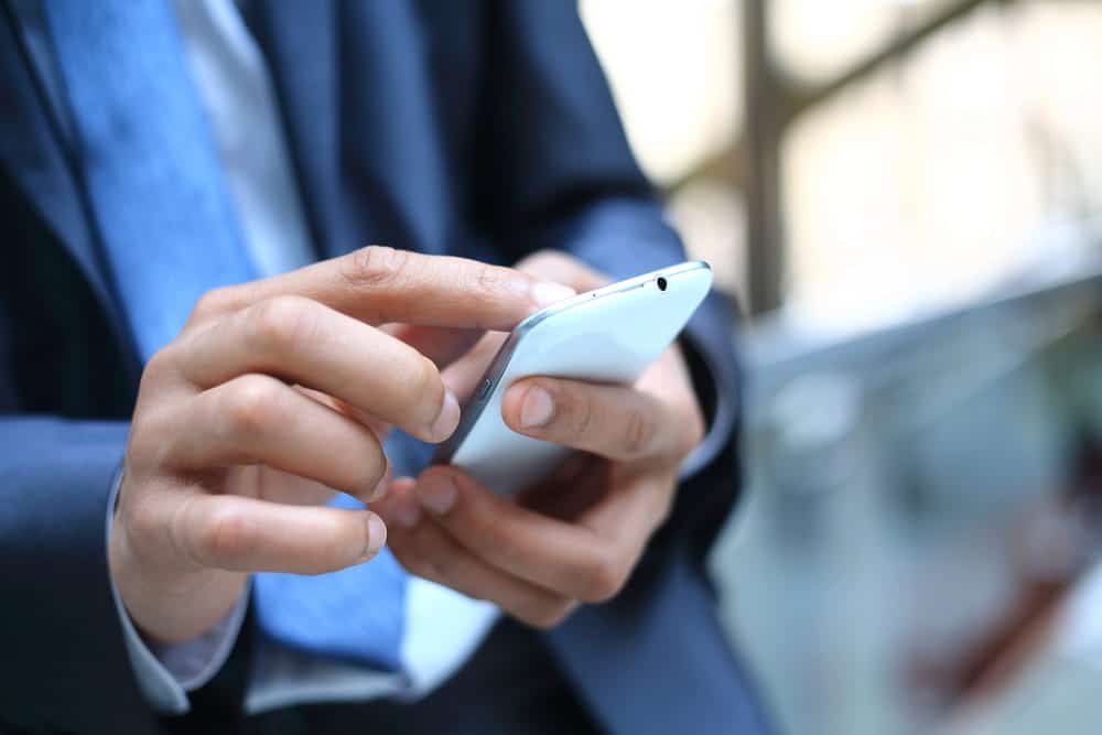 Image is of a person typing on a mobile phone, concept of digital communication and text conversations reviewed during DV cases.