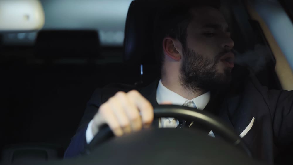 Image is of a driver sitting alone in a vehicle during a traffic stop investigation, concept of a drug arrest and evidence review.