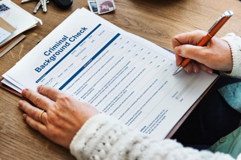 Image is of a person completing a criminal background check form, concept of how DUI charges may appear on background checks.