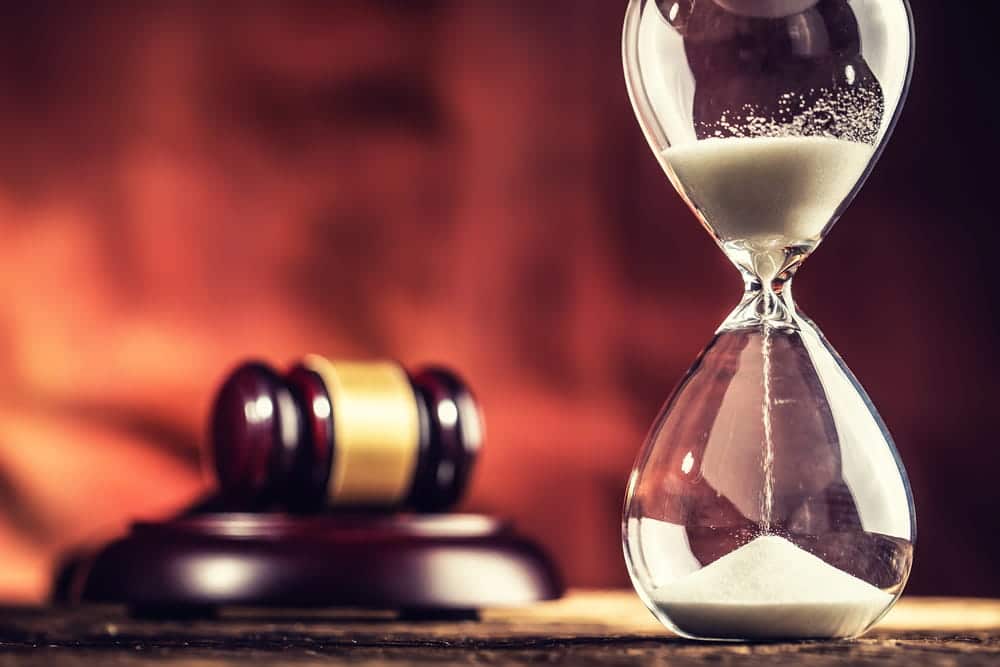 Image is of an hourglass beside a judge’s gavel, concept of a drug case timeline in Ponte Vedra Beach.