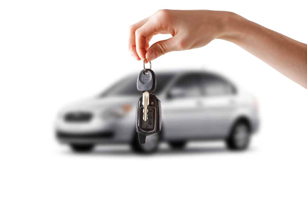 Image is of a person holding car keys in front of a vehicle, representing ignition interlock rules after a DUI.