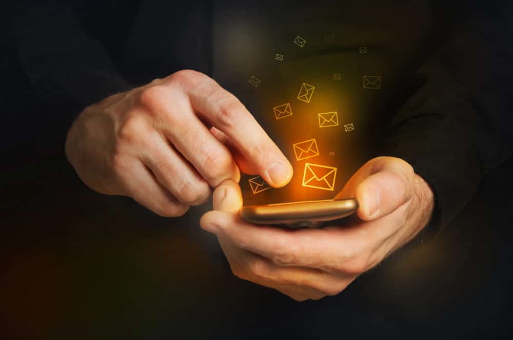 Image of a person using a smartphone with digital message icons, representing electronic contact restrictions following a DV Arrest in Ponte Vedra Beach.